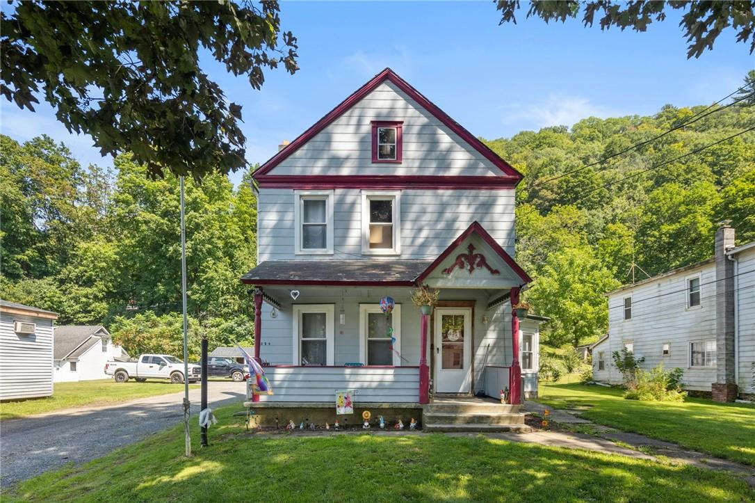 View of front of property with a front lawn and covered porch