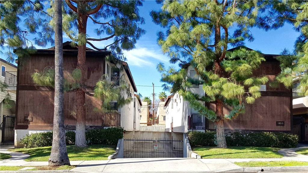 a front view of a house with a yard and fountain in middle