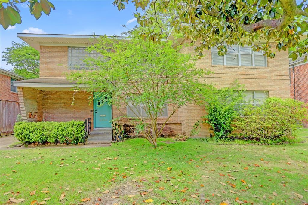 a view of a house with backyard and a tree