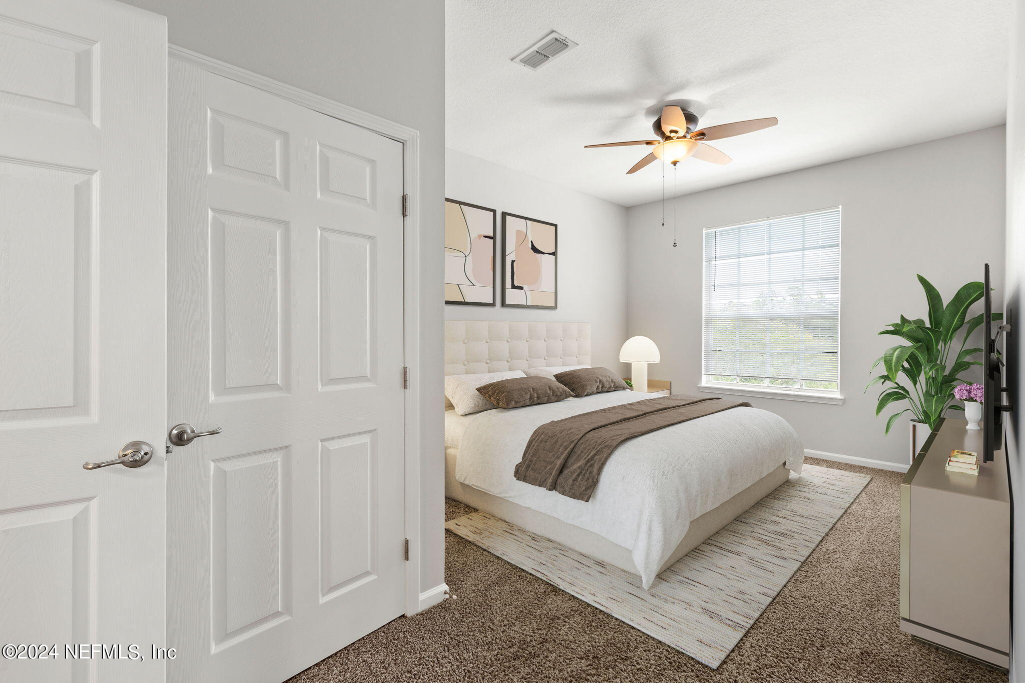 a bedroom with a large bed and a chandelier