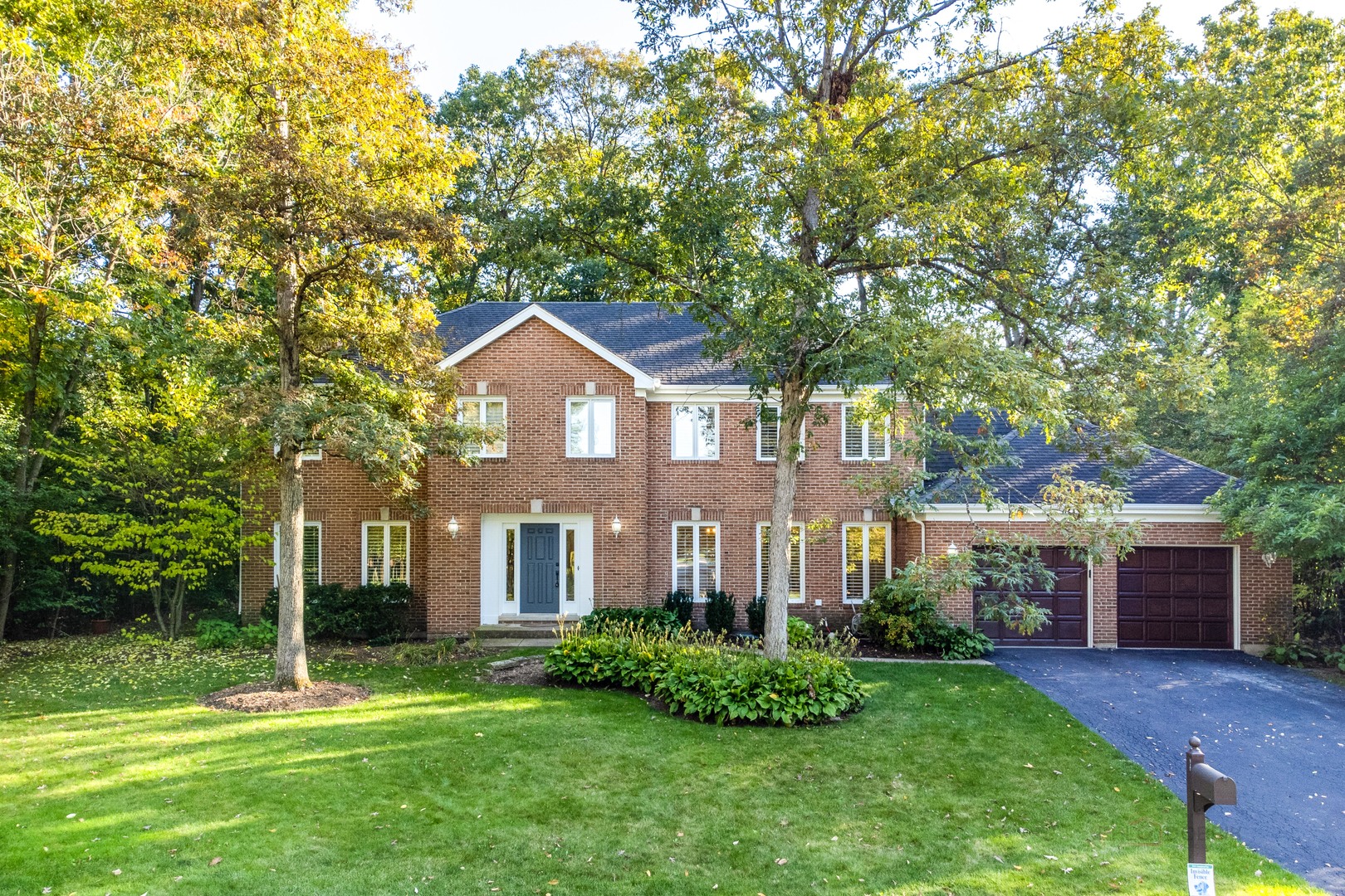 a front view of a house with a yard and trees