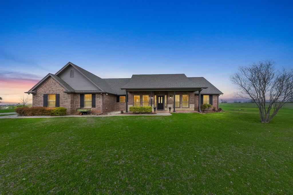 a front view of a house with yard and green space