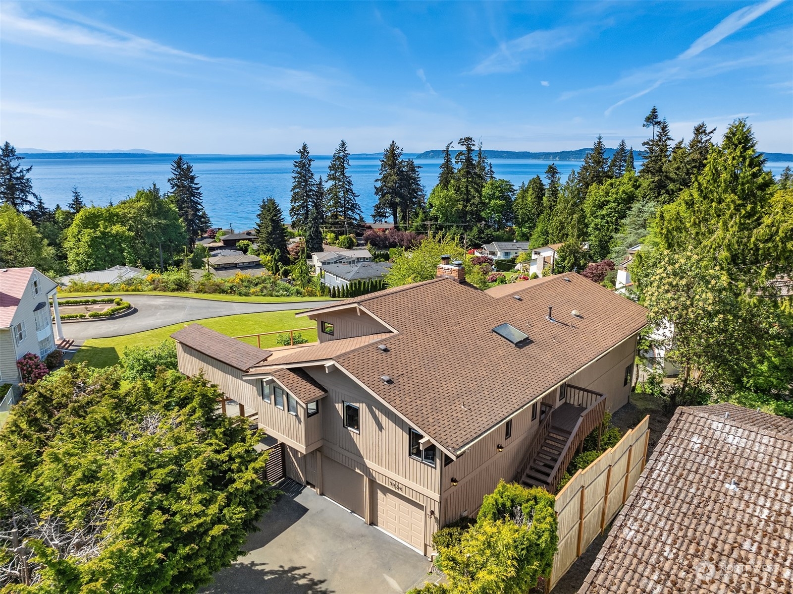 a aerial view of a house with a yard and lake view