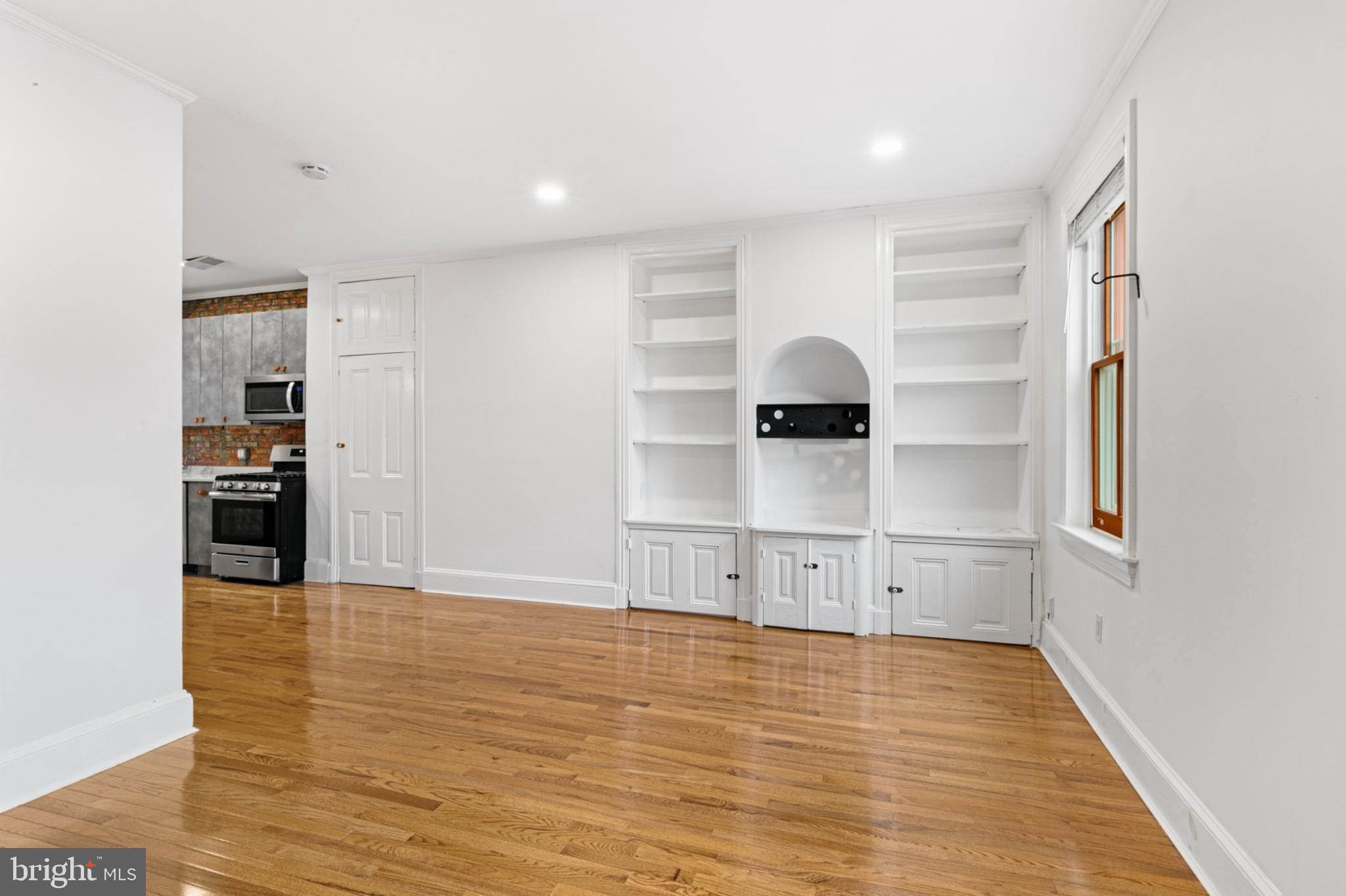 a view of empty room with wooden floor and window