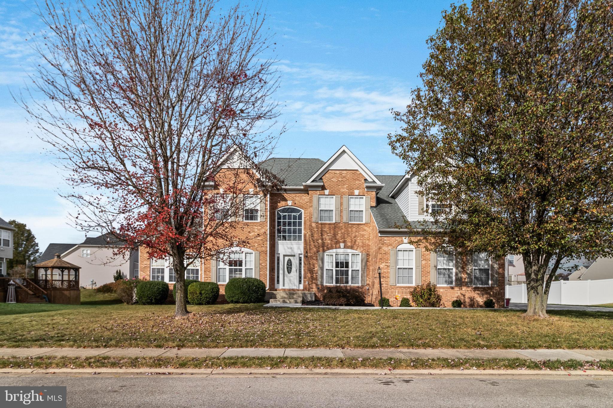 a view of a big house with a big yard and large trees