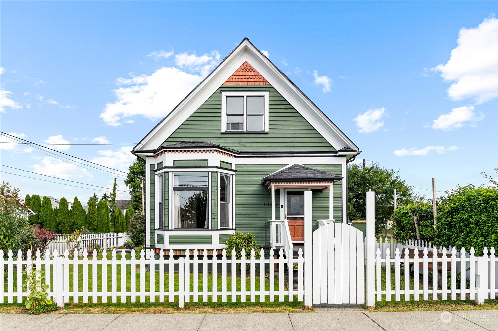 a front view of a house with a white fence