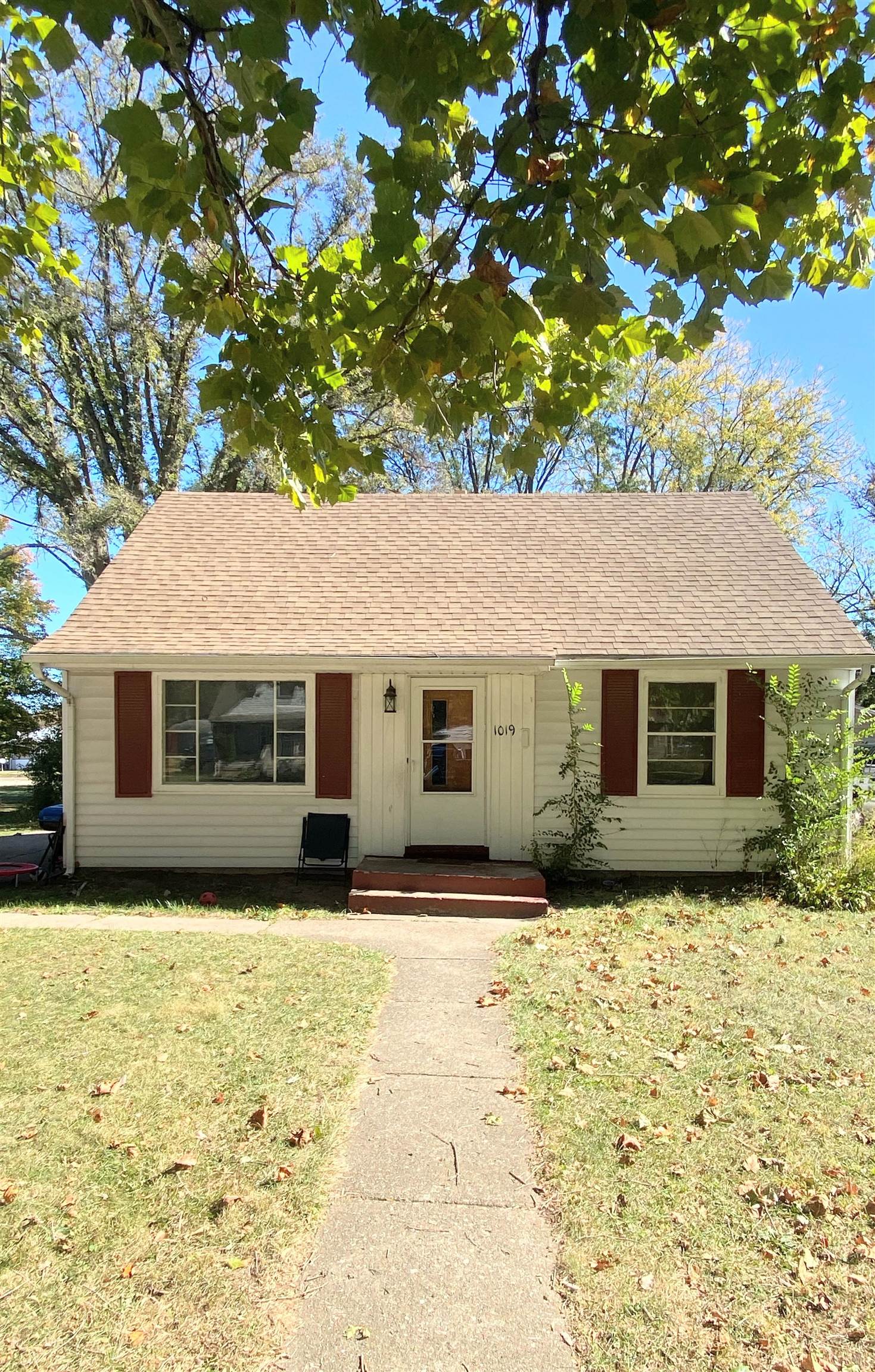 a front view of house with yard and trees in the background