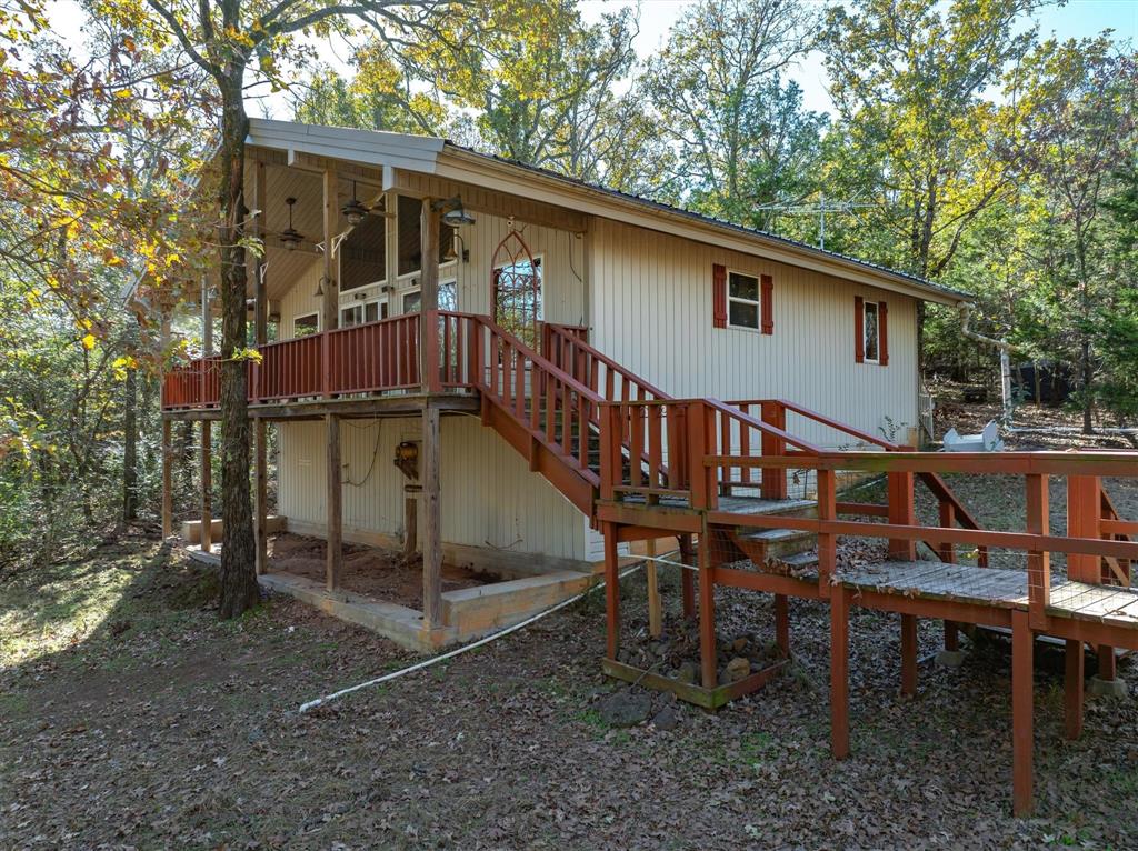 a backyard of a house with wooden deck and outdoor seating