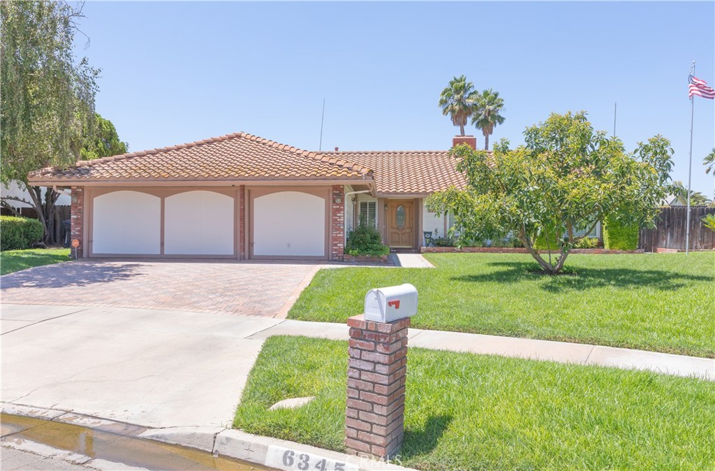 a front view of a house with a yard and fountain