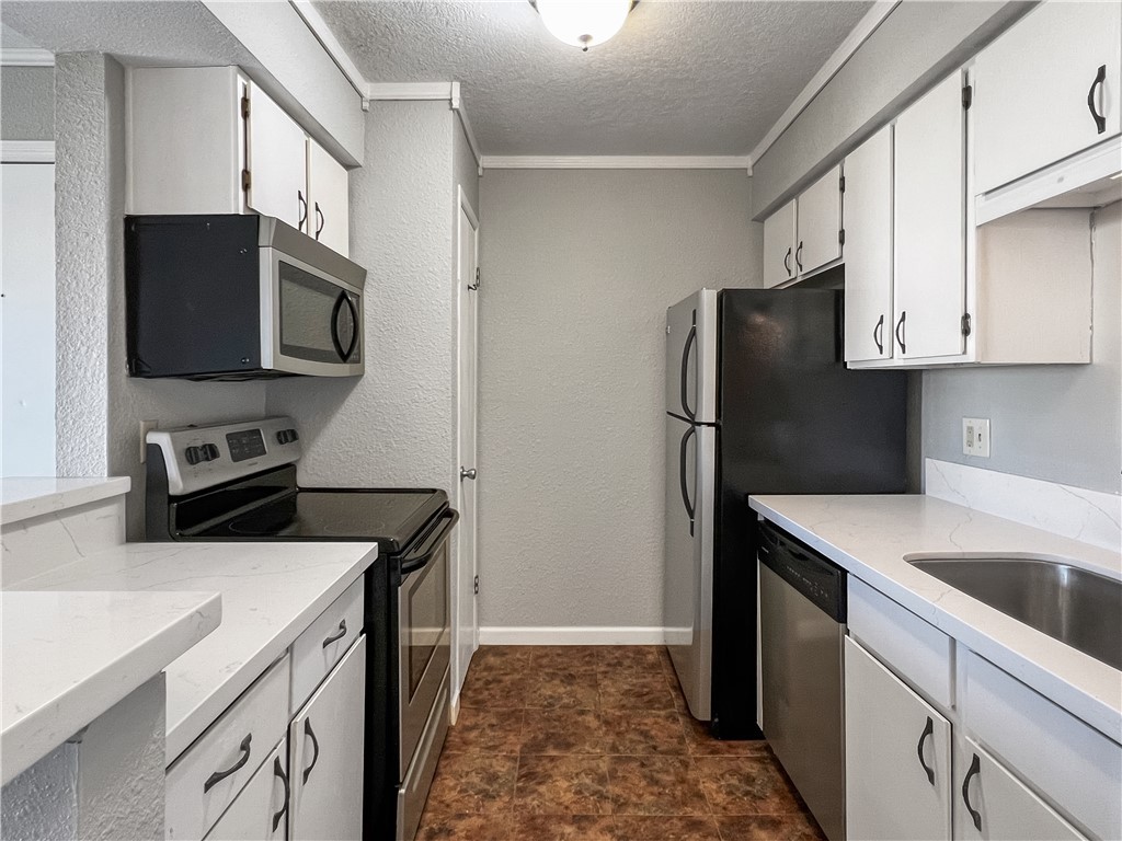 Kitchen featuring a textured ceiling, white cabine