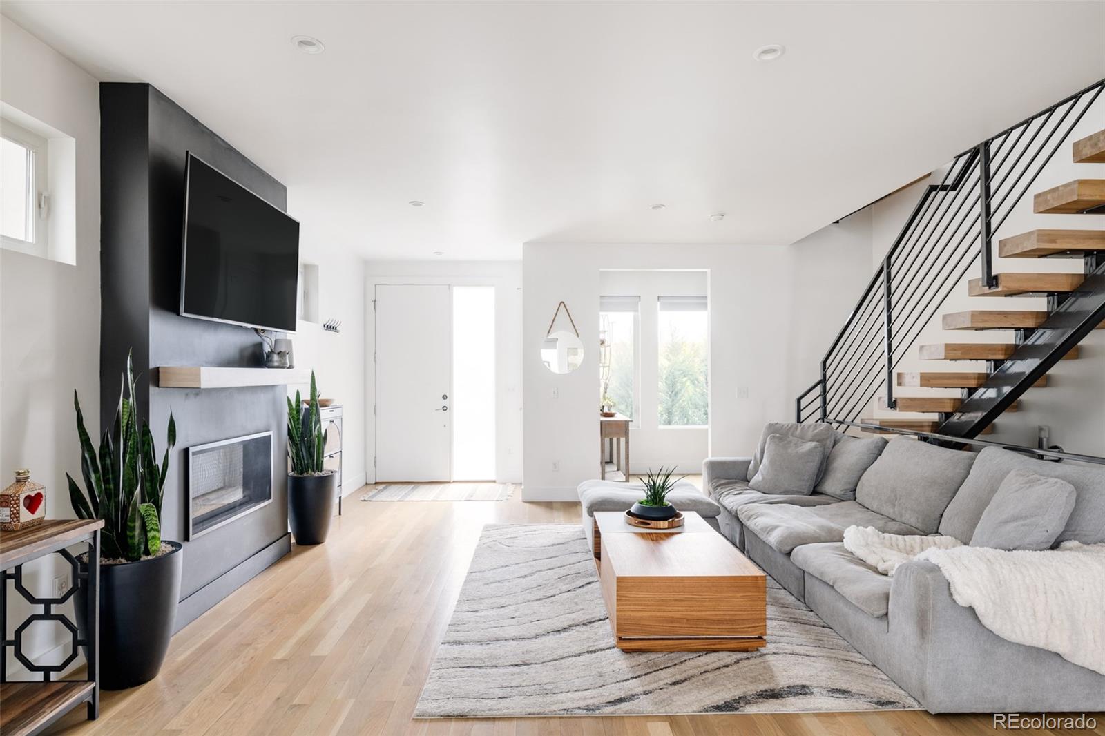 a living room with furniture a flat screen tv and a fireplace