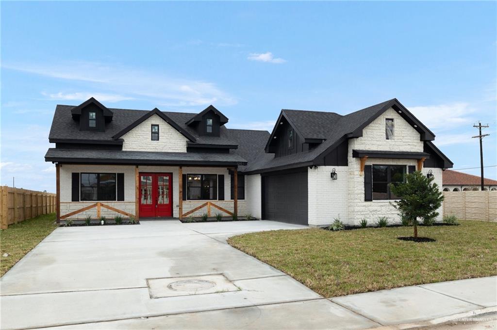 View of front facade featuring a front yard and a garage