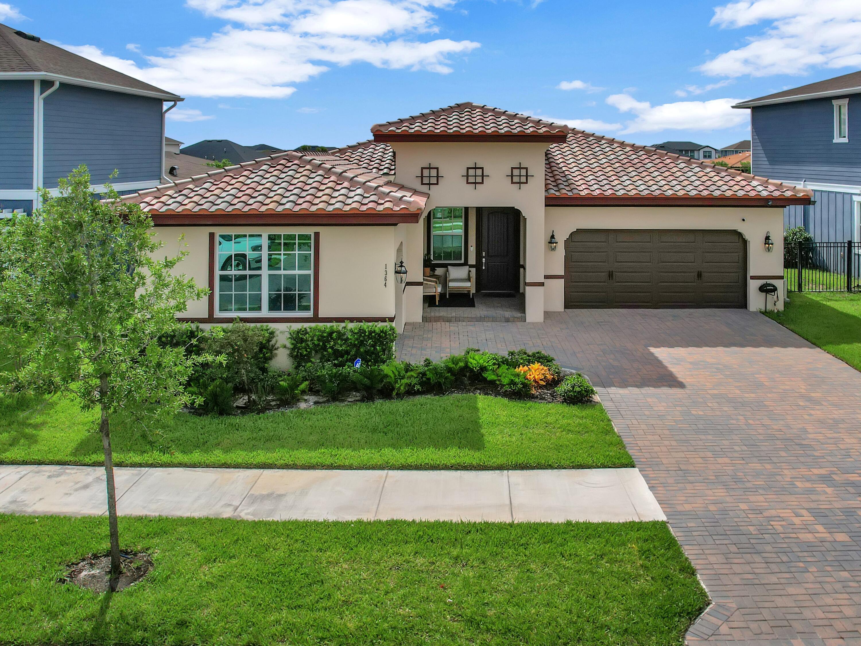 a front view of a house with a garden and plants