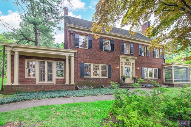 front view of a brick house with a yard