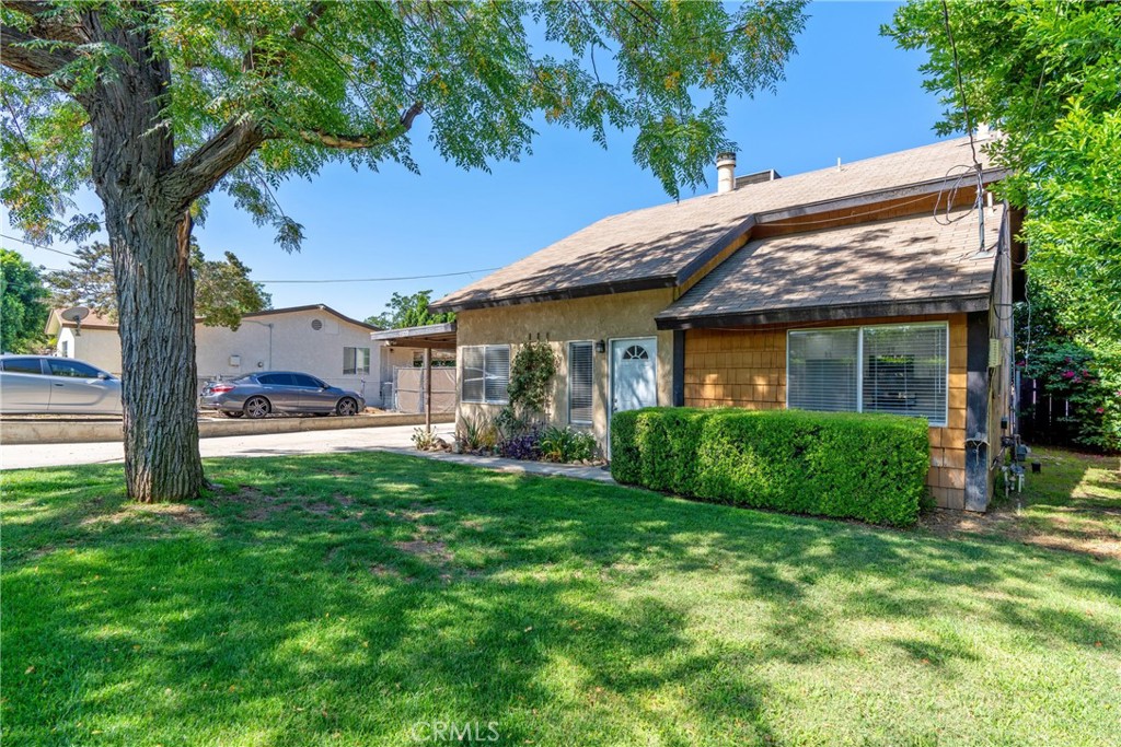 a view of a house with a yard and tree s