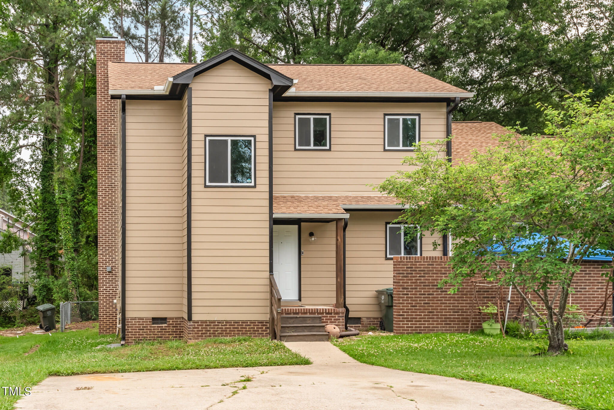 a front view of a house with a yard and an trees