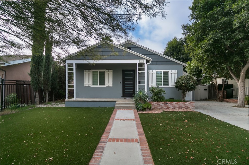 a front view of a house with a garden and yard