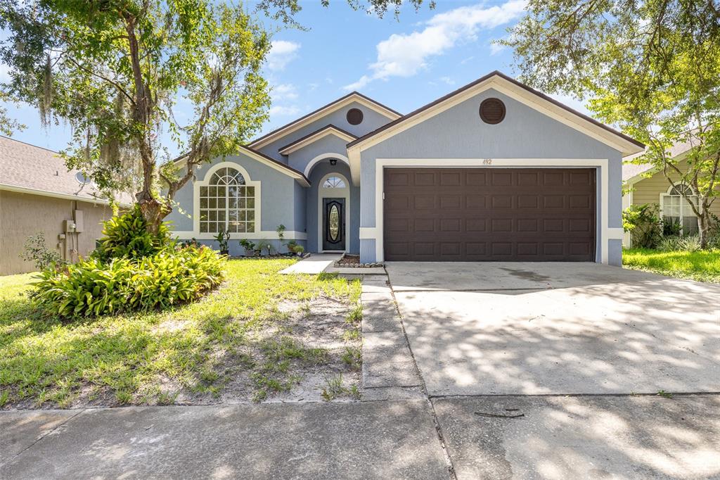 a front view of a house with a yard and garage