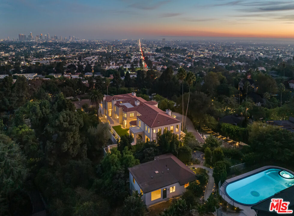 an aerial view of residential houses with outdoor space and trees