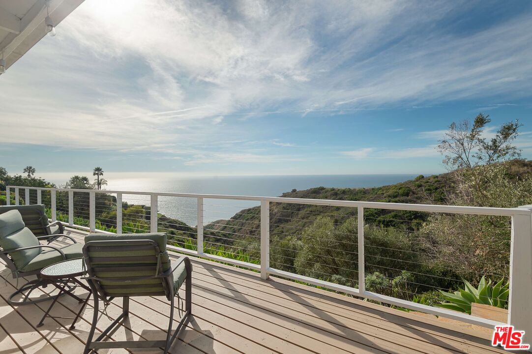 a view of a balcony with two chairs and a table