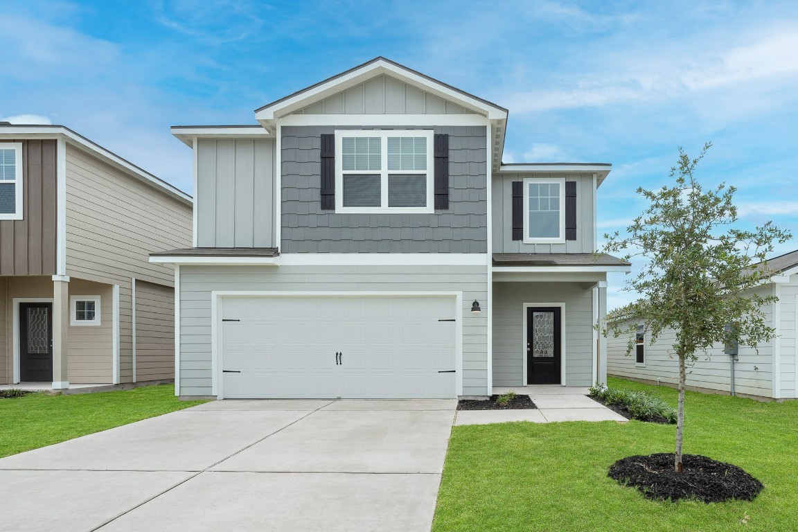 a front view of a house with a yard and garage