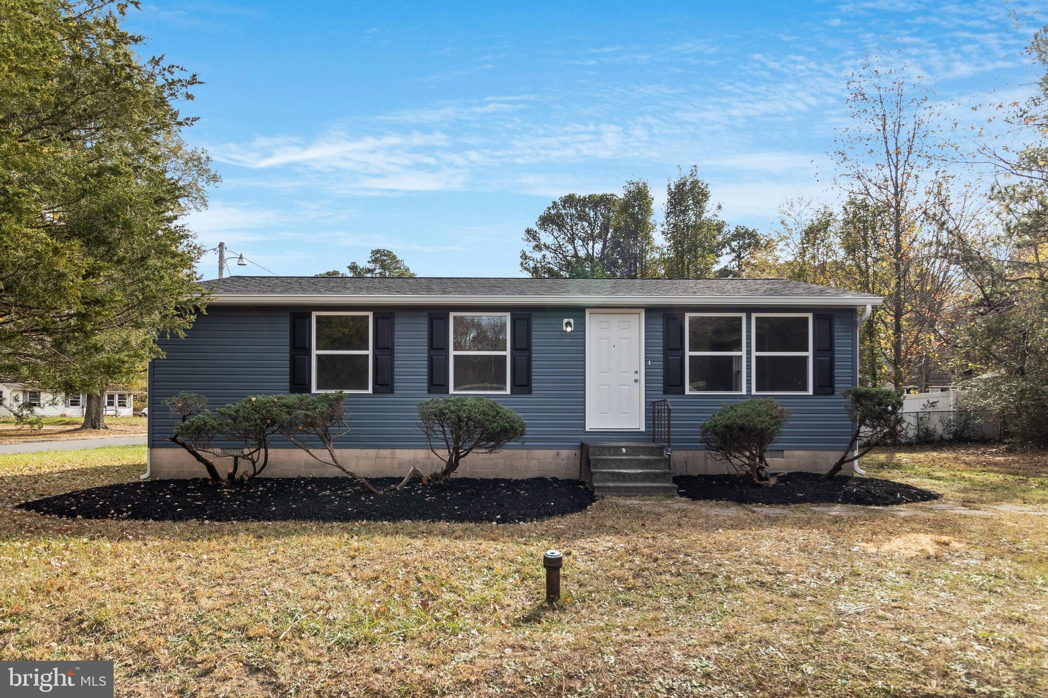 a front view of a house with a yard and outdoor seating