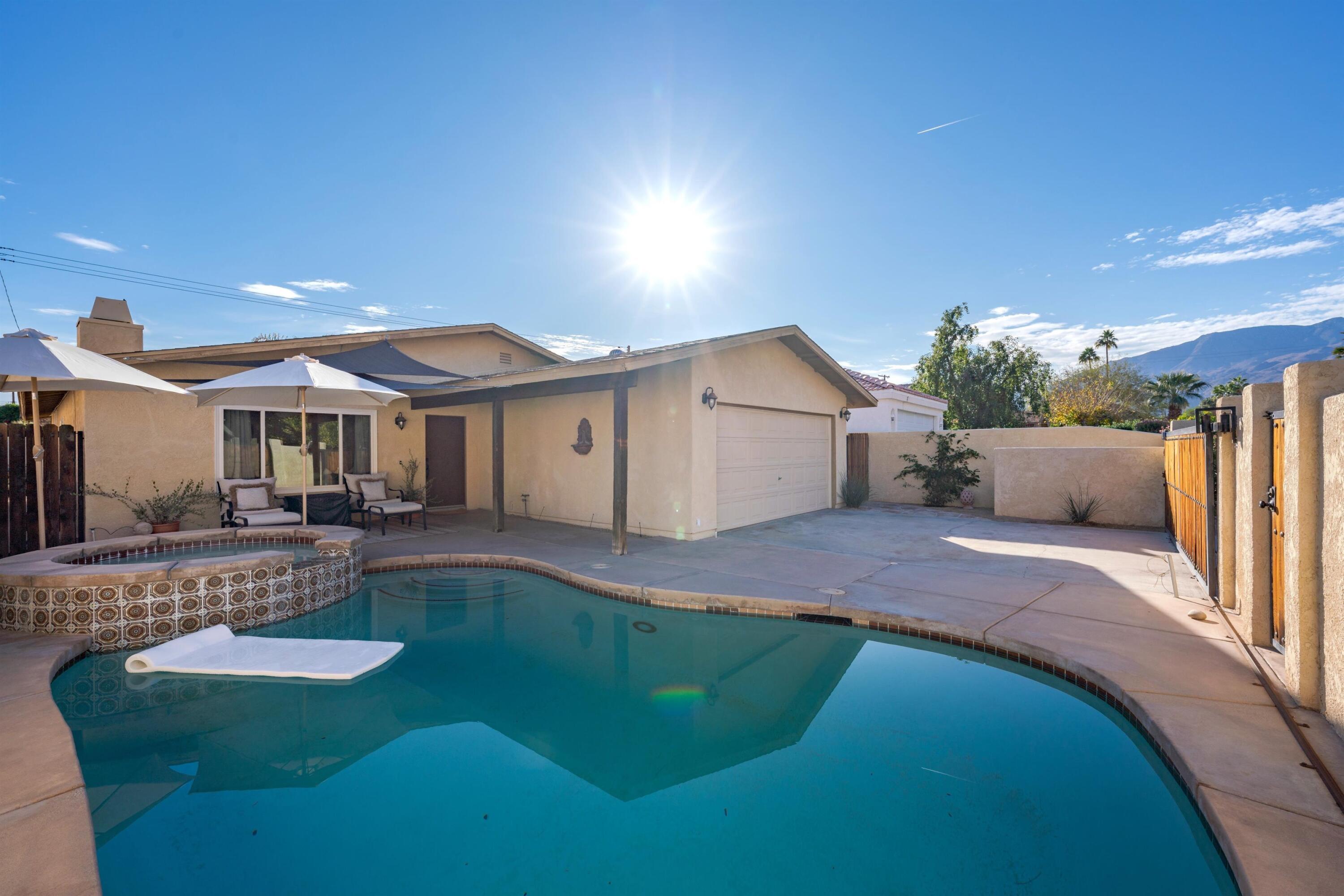 a view of a house with backyard and sitting area