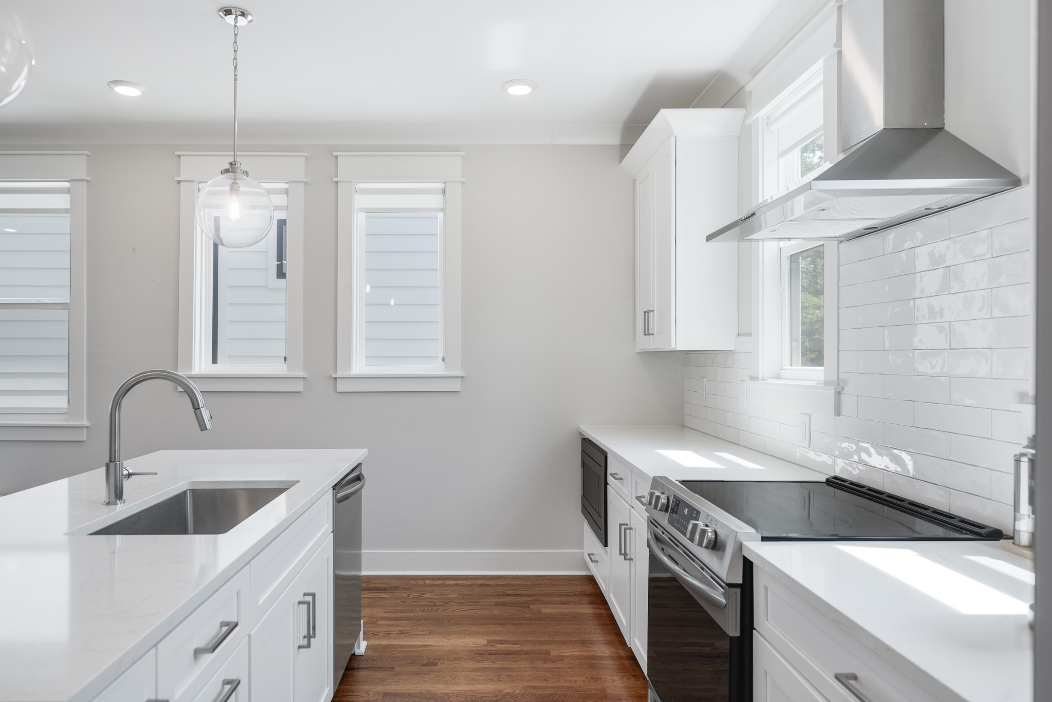 Chef's Kitchen features tile and all white cabinetry an island, marble countertops, an electric stainless steel stove and vent.