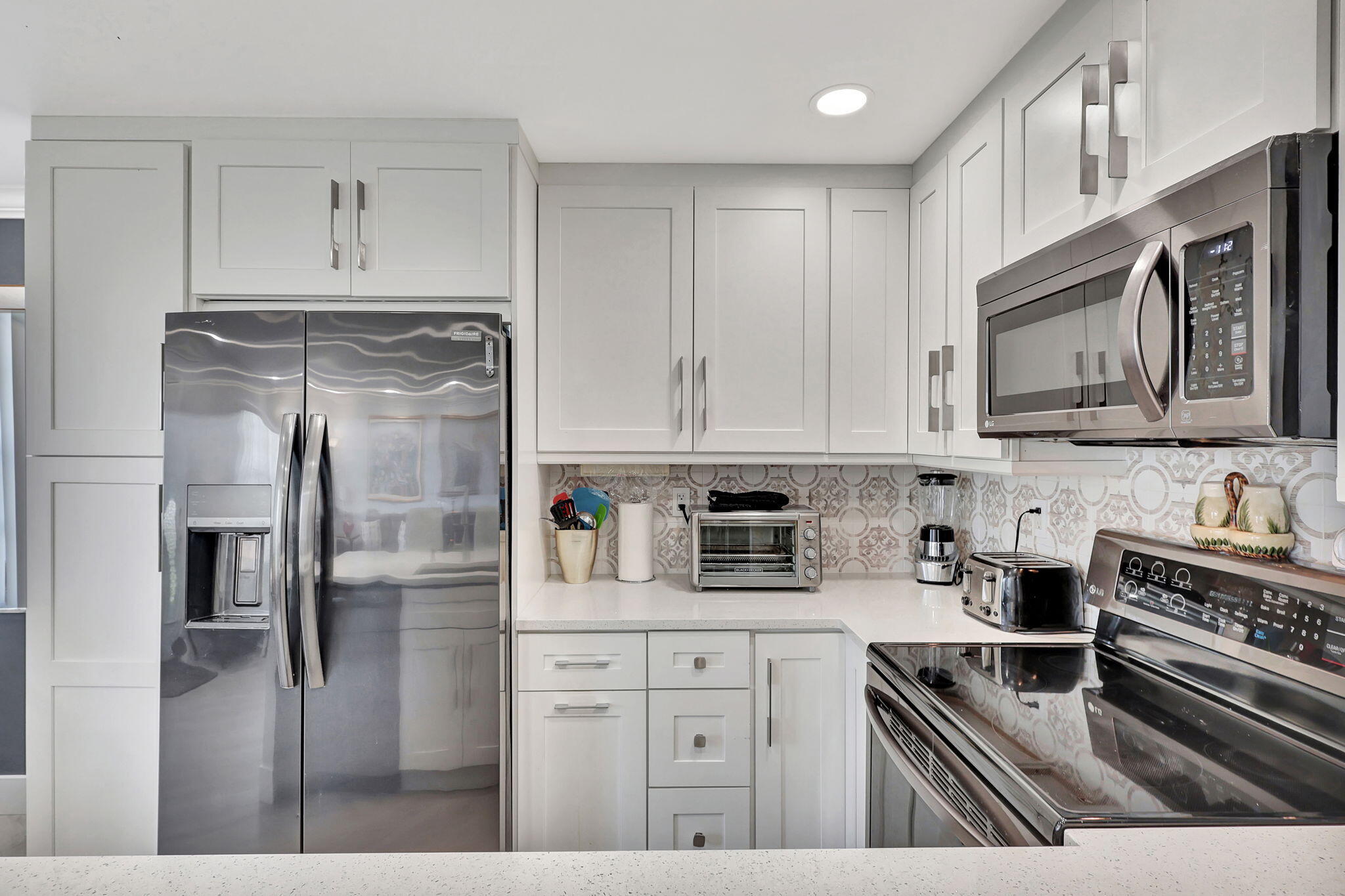 a kitchen with stainless steel appliances granite countertop a refrigerator a stove and a sink