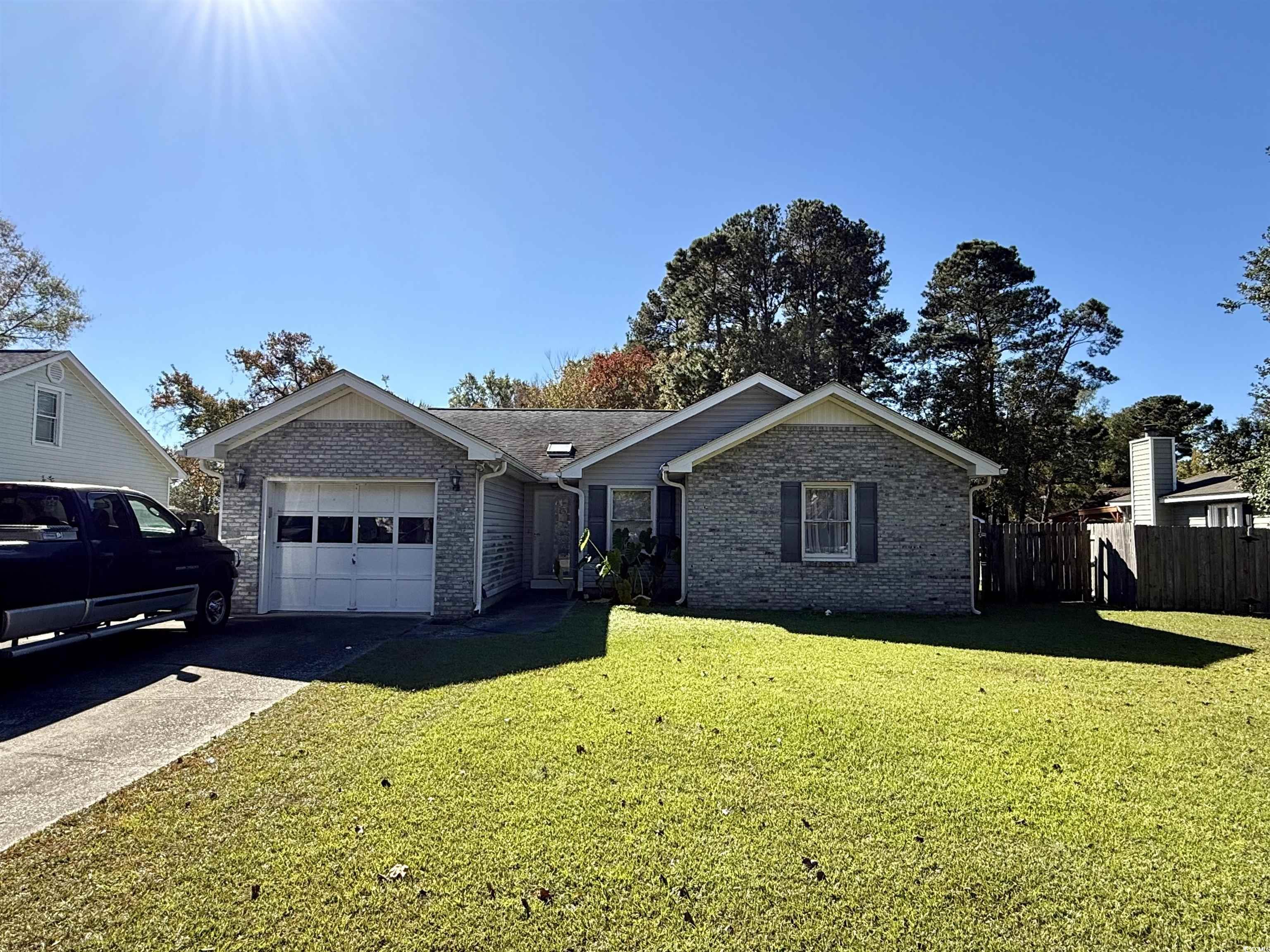 Single story home with a front lawn and a garage