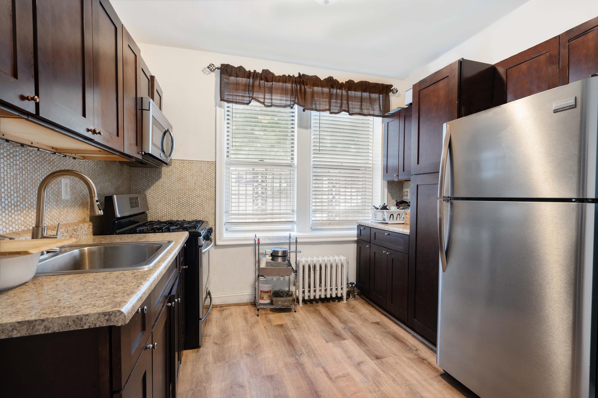 a kitchen with granite countertop a refrigerator and a sink