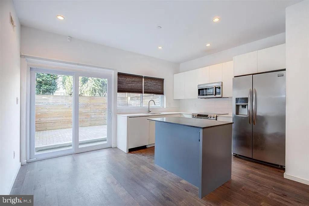 a kitchen with stainless steel appliances granite countertop a refrigerator and a stove top oven