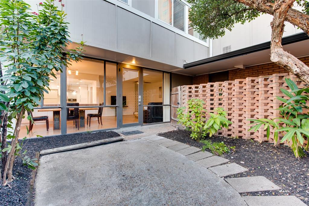 a view of a patio with table and chairs potted plants and large tree