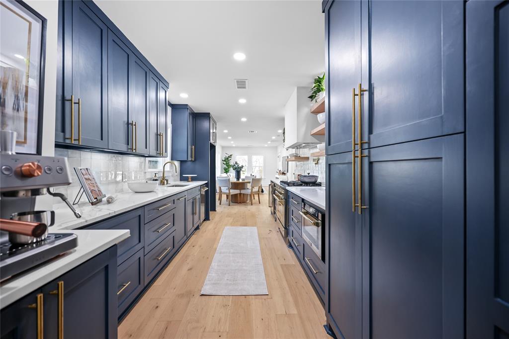 a kitchen with kitchen island granite countertop stainless steel appliances cabinets a sink and a counter space