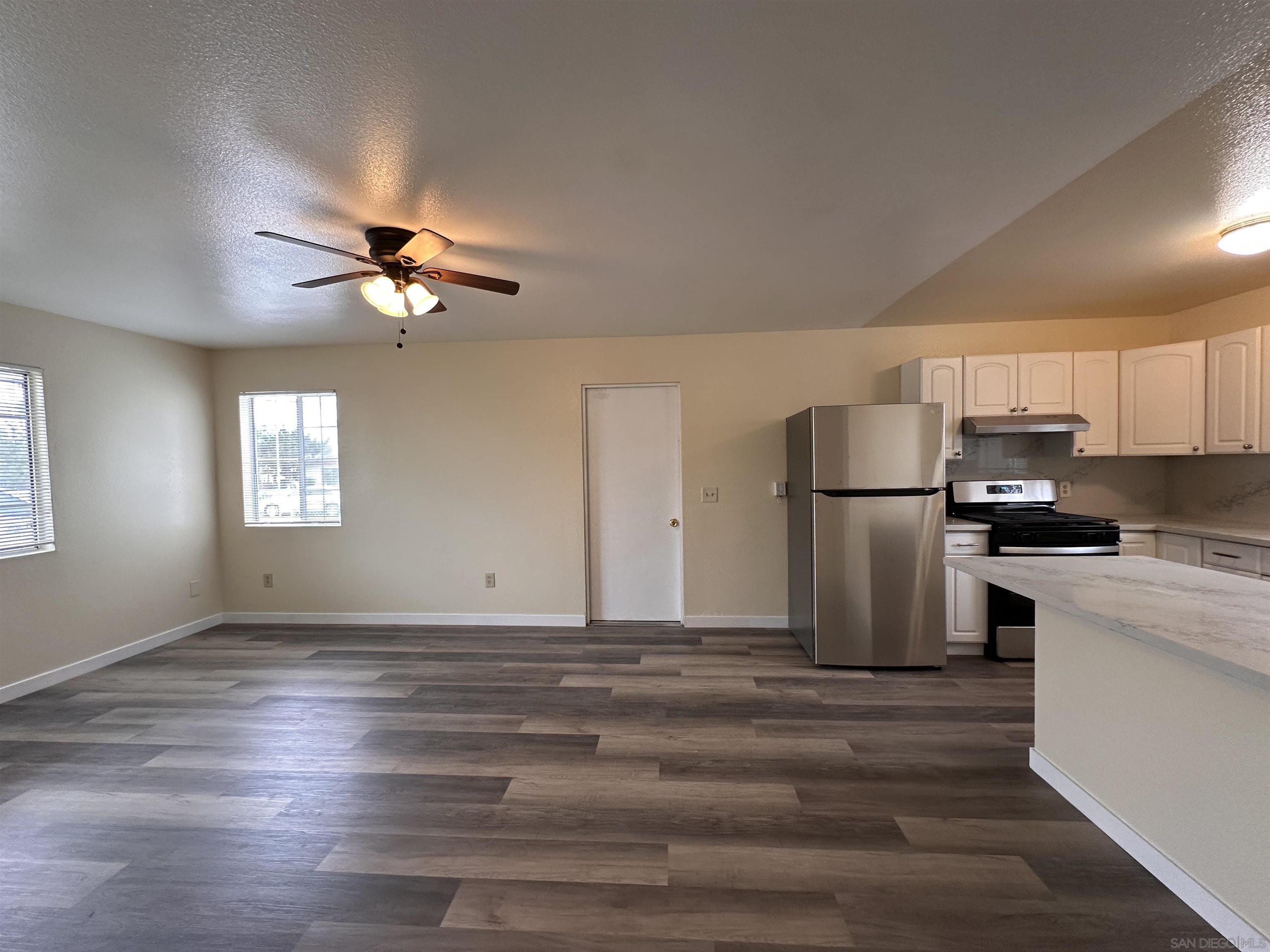 a kitchen with kitchen island a sink stainless steel appliances and refrigerator