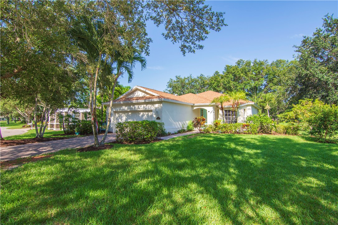 a front view of a house with a yard and trees