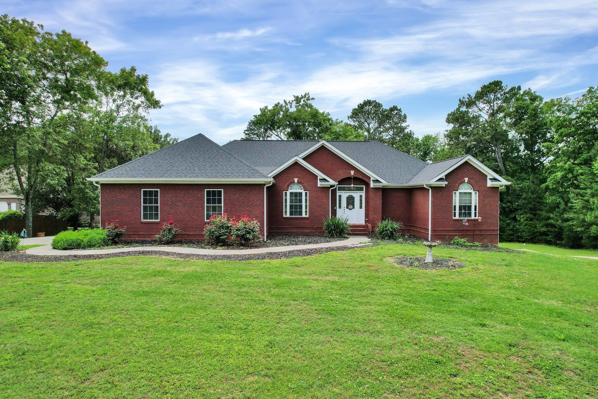 a front view of a house with yard and green space