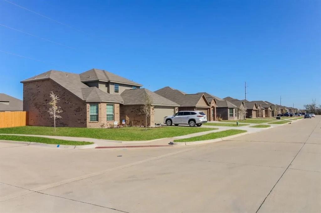 a front view of a house with a yard and road