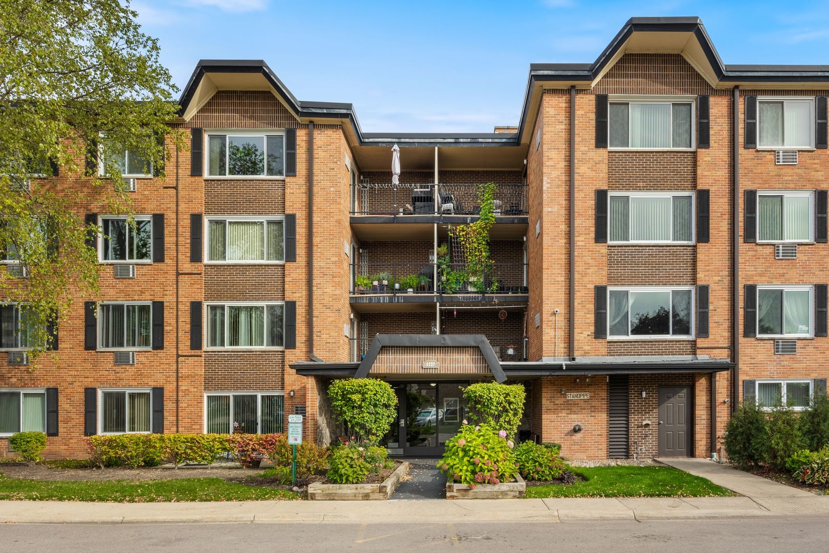 a front view of a residential apartment building with a yard