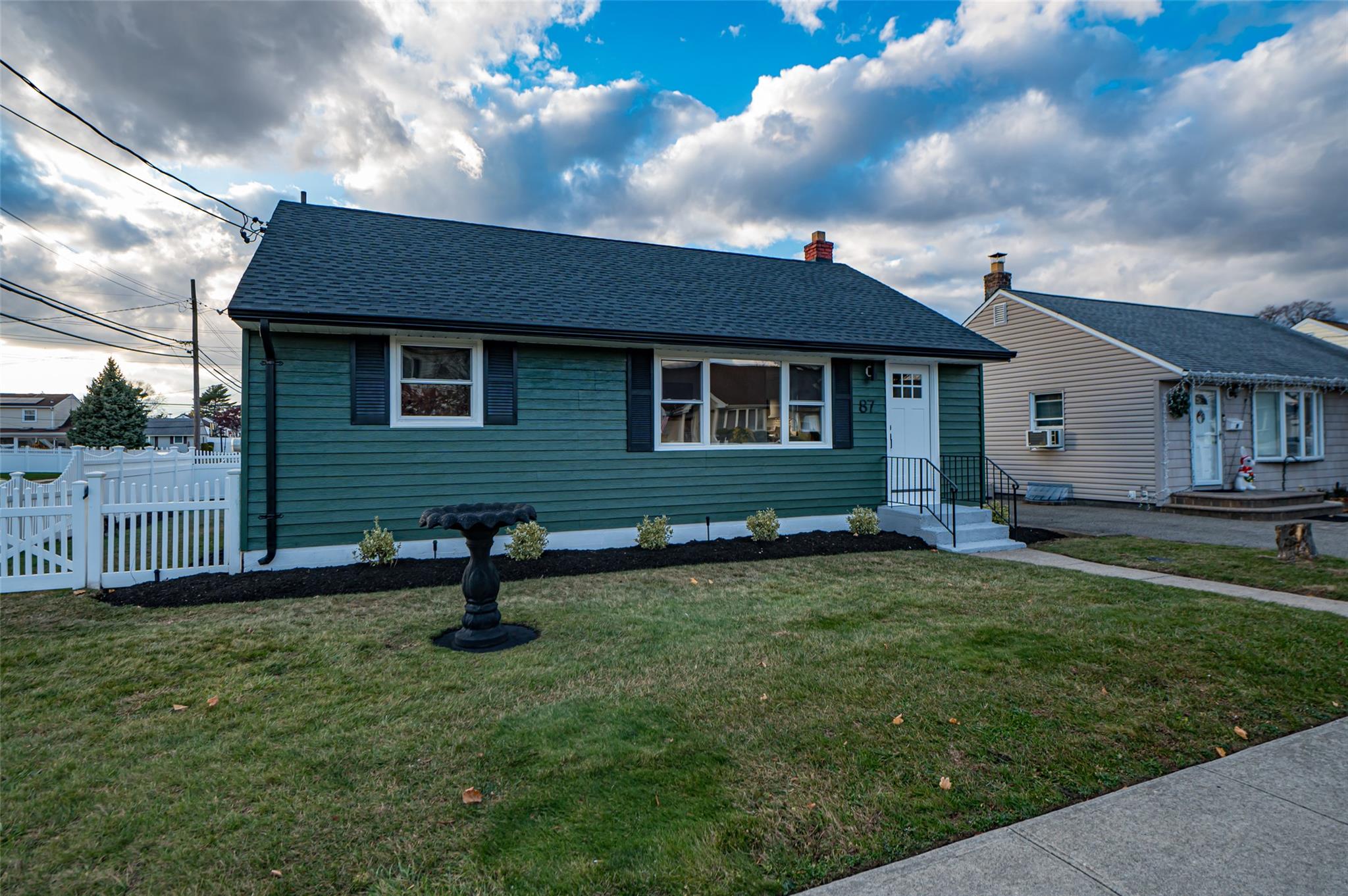 View of front of house with a front yard and cooling unit