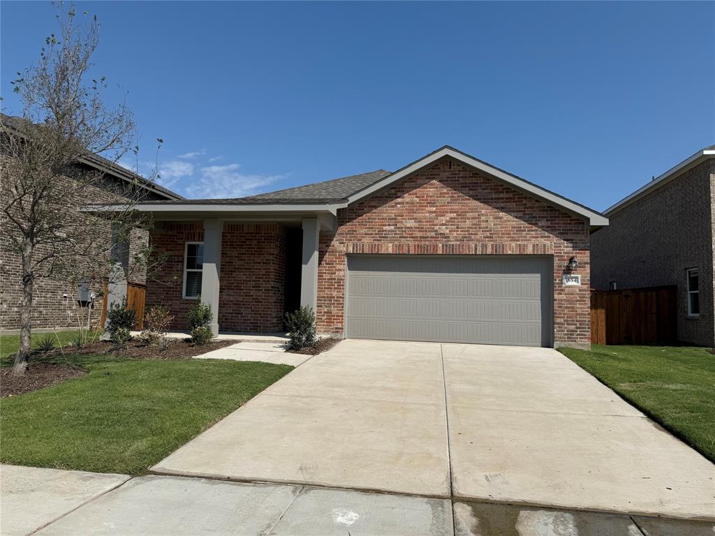 a front view of a house with yard and trees