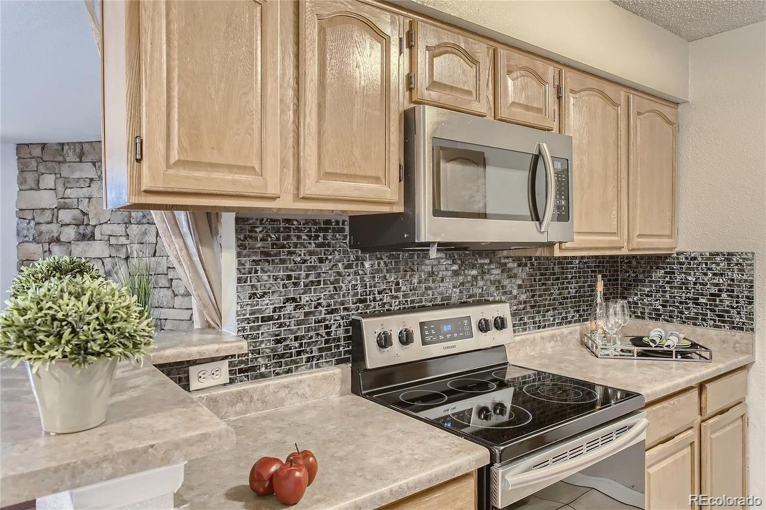 a kitchen with granite countertop a stove a sink and a microwave