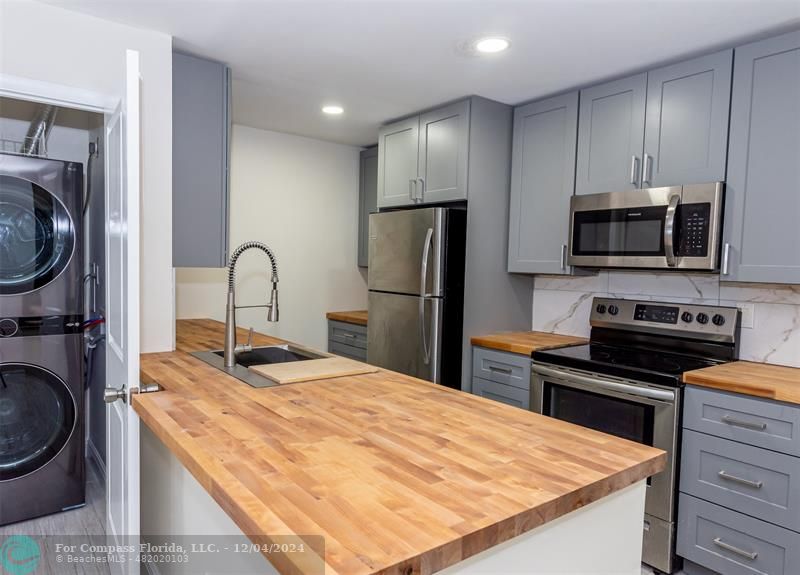 a kitchen with a appliances a sink and cabinets