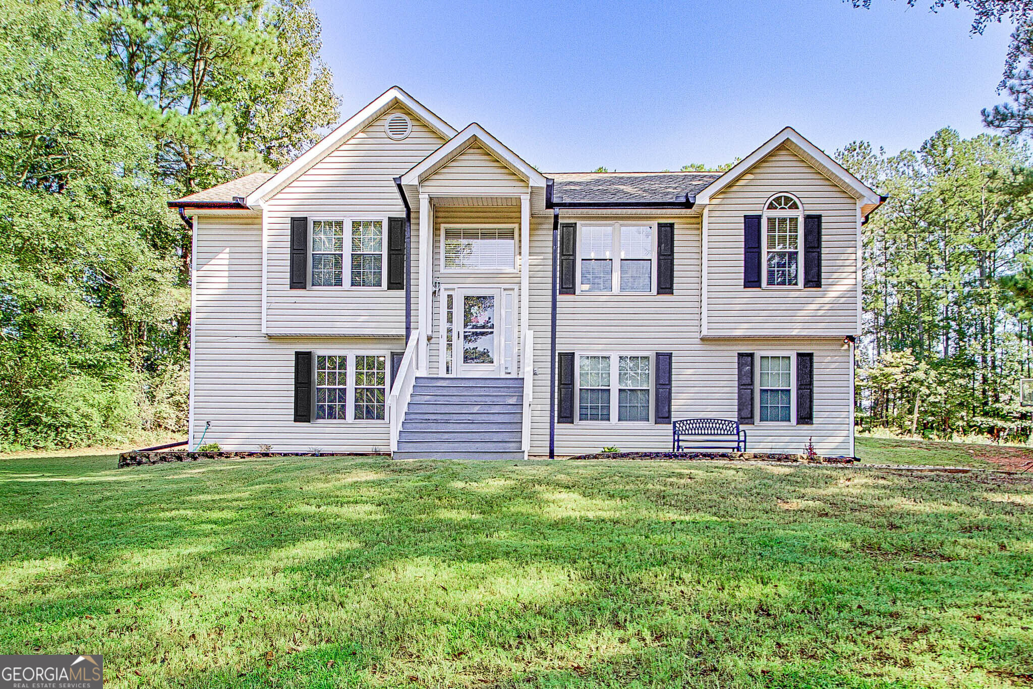 a front view of a house with a yard and trees