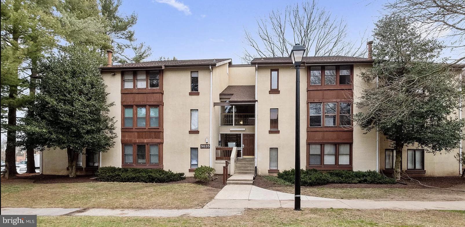 a front view of a residential apartment building with a yard