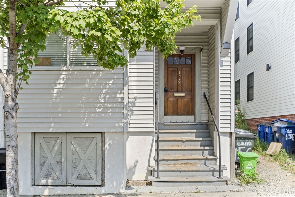 a view of a house with a door and a tree