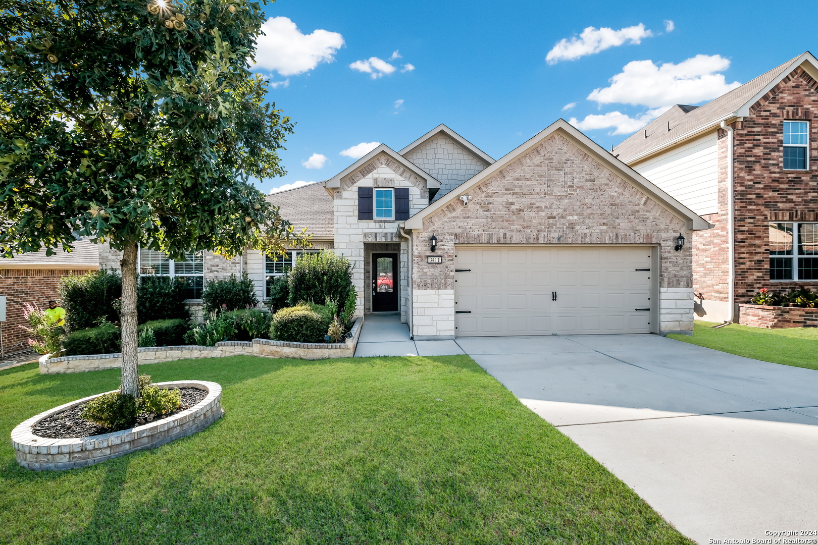 a front view of a house with a yard garage and outdoor seating