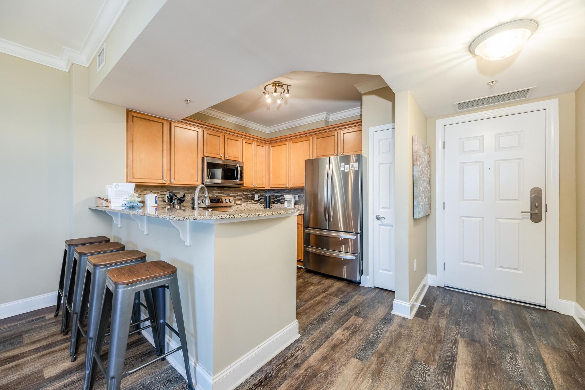 a kitchen with kitchen island granite countertop wooden floors and stainless steel appliances