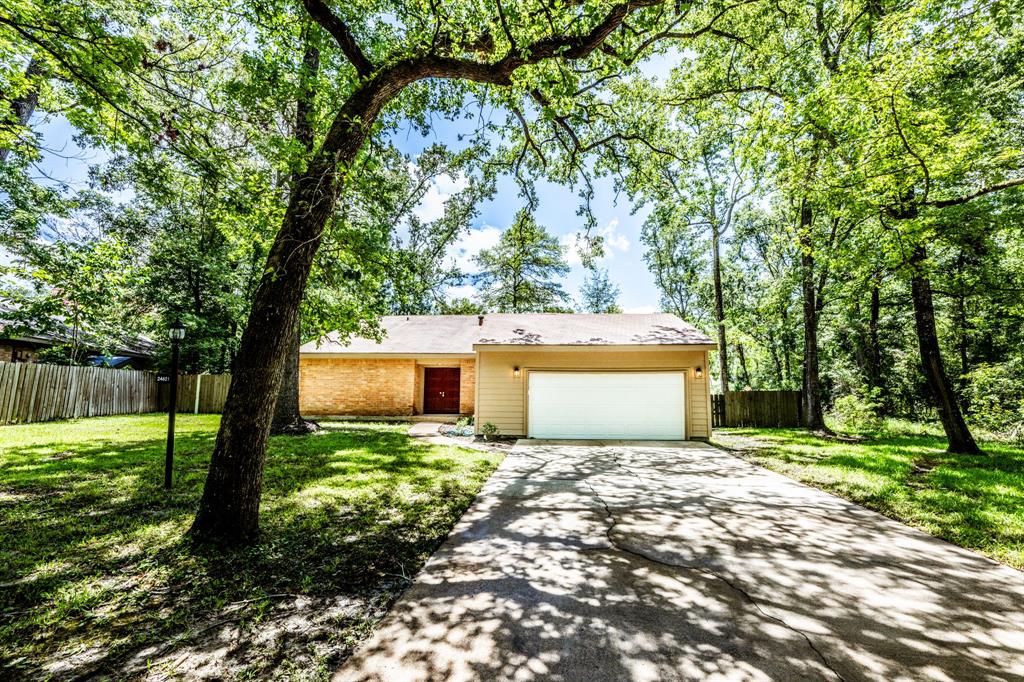 a front view of a house with a yard and tree