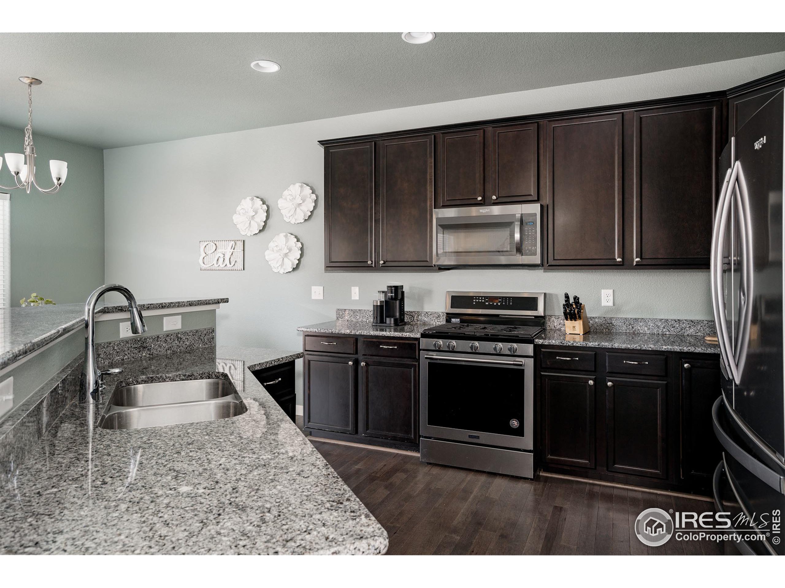 a kitchen with kitchen island granite countertop a stove and a sink